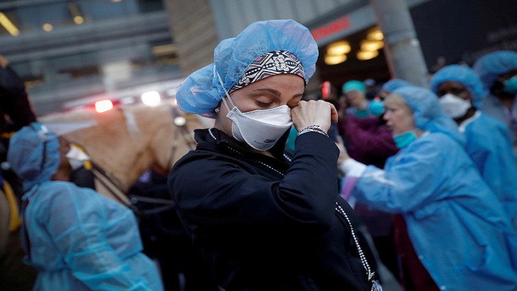 A nurse wipes away tears as she stands outside NYU Langone Medical Center on 1st Avenue in Manhattan as New York Police Department (NYPD) Mounted Police and other units came to cheer and thank healthcare workers at 7pm during the outbreak of the coronavirus disease (COVID-19) in New York City, New York, U.S., April 16, 2020.