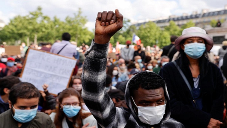 A demonstrator wearing a protective face mask raises his fist during a protest at the Place de la Republique square, following the death of George Floyd in Minneapolis police custody, in Paris, France, June 9, 2020.