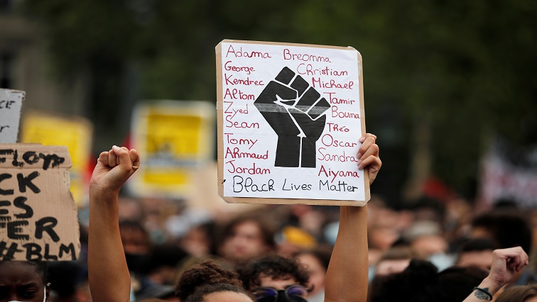 A demonstrator holds a placard during a protest against police brutality and the death in Minneapolis police custody of George Floyd.