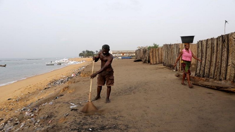 Jacob Amedrana, 47, who said he had to leave his home as it was destroyed by coastal erosion, sweeps the floor in front of his temporary home which is now also under threat of coastal erosion, in Baguida, Togo, February 25, 2020.