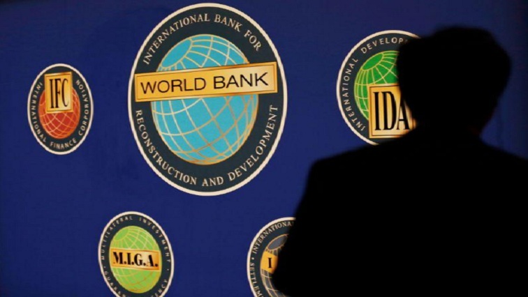 A man is silhouetted against the logo of the World Bank at the main venue for the International Monetary Fund (IMF) and World Bank annual meeting in Tokyo in this file photo.