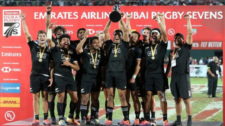 New Zealand players celebrate winning the final with the trophy.