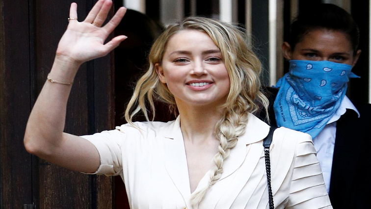 Actor Amber Heard waves as she arrives at the High Court in London, Britain July.