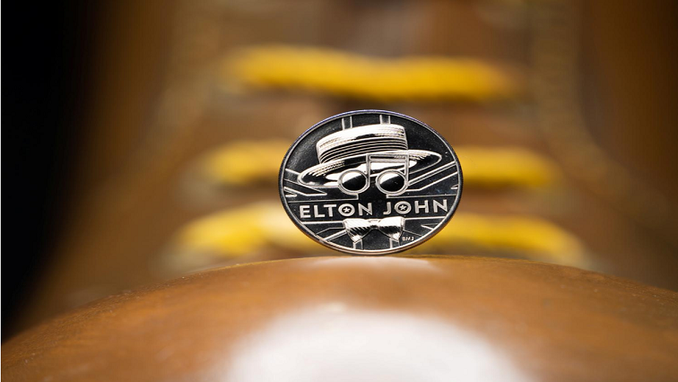 The coin sits on top of the boots worn by Elton John, acting as the Pinball Wizard in the musical film 'Tommy' in 1975, from the new competitive Elton John coin collection released by Britain's Royal Mint.