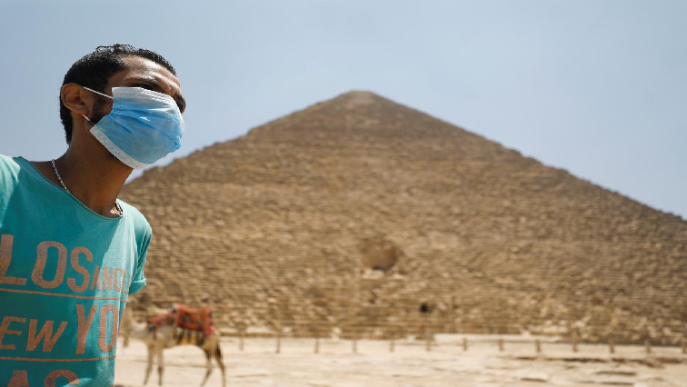 A man wearing a face mask is seen in front of the Great Pyramids of Giza after reopening for tourist visits, following the outbreak of the coronavirus disease (COVID-19), in Cairo, Egypt.