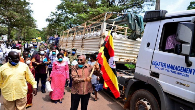 Uganda's Prime Minister Ruhankana Rugunda (C) flanked by ministers, walks next to trucks carrying relief food to be distributed to civilians affected by the lockdown, as part of measures to prevent the potential spread of coronavirus disease (COVID-19), in Kampala, Uganda April 4, 2020.
