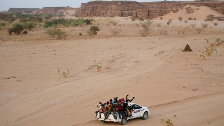 Migrants crossing the Sahara desert into Libya ride on the back of a pickup truck outside Agadez, Niger, May 9, 2016.