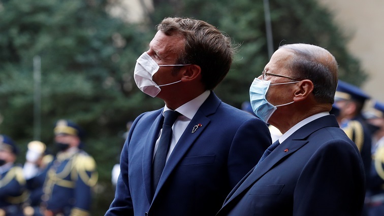 French President Emmanuel Macron and Lebanon's President Michel Aoun wear face masks as they arrive to attend a meeting at the presidential palace in Baabda.