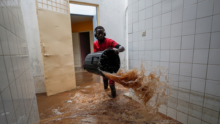 A volunteer removes water from a flooded health center after heavy rains in Guediawaye on the outskirts of Dakar.