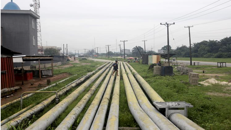 A woman walks over pipelines crisscrossing Ogoniland in Rivers State, Nigeria.