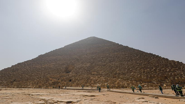 Workers wearing face masks and gloves swept and sprayed the walkways around the bases of the pyramids, as well as the ticket office and a visitor center.