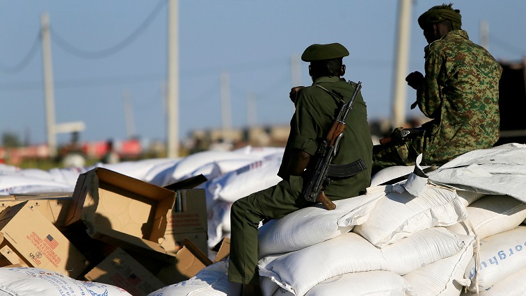 Armed men guard sacks of food delivered to Ethiopian refugees fleeing from the ongoing fighting in Tigray region, at the Fashaga camp, on the Sudan-Ethiopia border.
