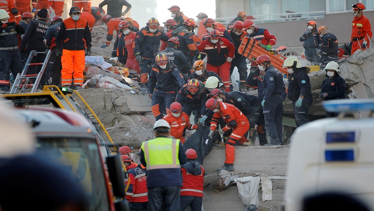 Rescue workers carry an earthquake victim out of a collapsed building in the Aegean port city of Izmir, Turkey.