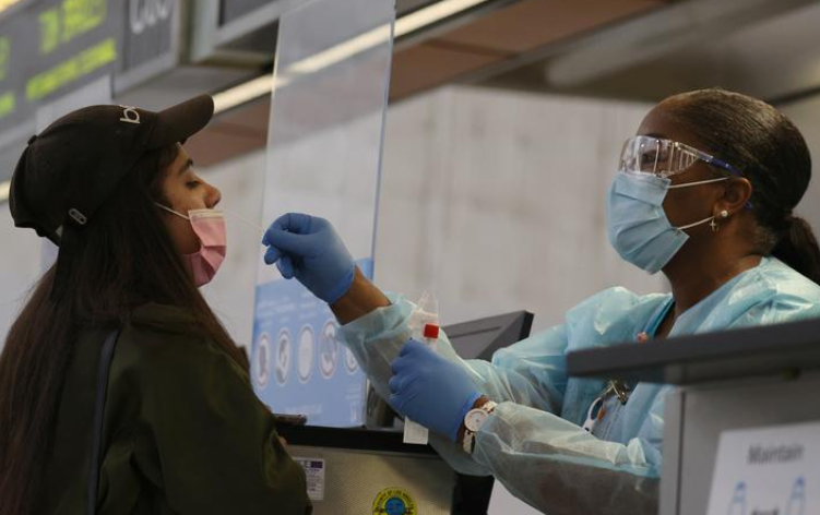 Hannah Osnan, 18, is given a 24-hour rapid coronavirus test by nurse Caren Williams at Tom Bradley international terminal at LAX airport so she can travel to Egypt to see family, as the global outbreak of the coronavirus disease (COVID-19) continues.