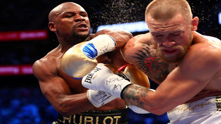 [File photo] Floyd Mayweather Jr. lands a hit against Conor McGregor during their boxing match at the at T-Mobile Arena.