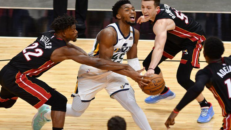 Utah Jazz guard Donovan Mitchell (45) is fouled by Miami Heat guard Duncan Robinson (55) as Miami Heat forward Jimmy Butler (22) follows on the play in the fourth quarter at American Airlines Arena.
