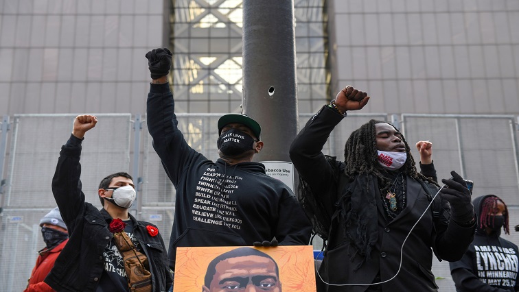 Protesters raise their fists and chant after the "I Can't Breathe"  Silent March for Justice a day before jury selection is scheduled to begin for the trial of Derek Chauvin.