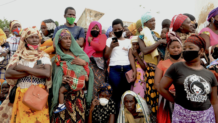 People wait for friends and relatives as a ship carrying more than 1,000 people fleeing an attack claimed by Islamic State-linked insurgents on the town of Palma, docks in Pemba, Mozambique, on April 1, 2021.