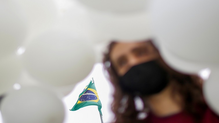 A nurse holds balloons during a protest asking for COVID-19 vaccines and in favour of SUS (Unique Health System) during World Health Day in Brasilia