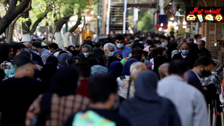 Iranians wearing protective face masks against the coronavirus walk in a crowded area of the capital Tehran, Iran. [File image]