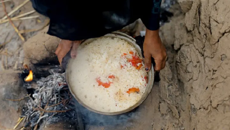 A person holds a pot with rice