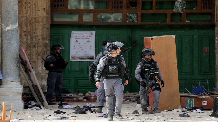 Israeli police walk in front of the closed doors of Al-Aqsa Mosque during clashes with Palestinians at the compound that houses  known to Muslims as Noble Sanctuary and to Jews as Temple Mount, in Jerusalem's Old City.