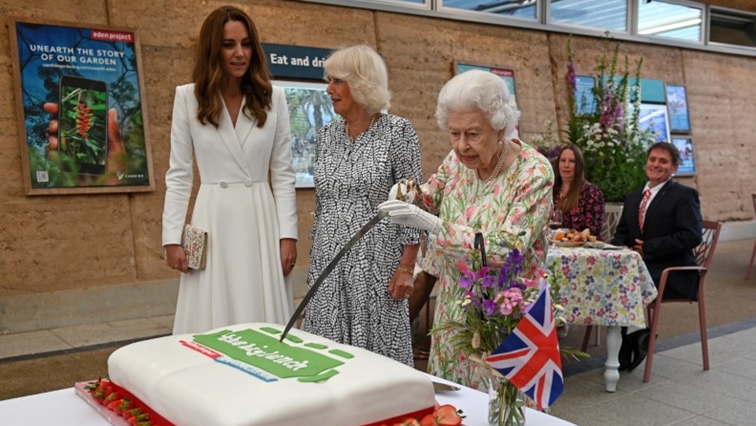 Britain's Queen Elizabeth attempts to cut a cake with a sword next to Camilla, Duchess of Cornwall, and Catherine, Duchess of Cambridge as they attend a drinks reception on the sidelines of the G7 summit, at the Eden Project in Cornwall, Britain June 11, 2021.
