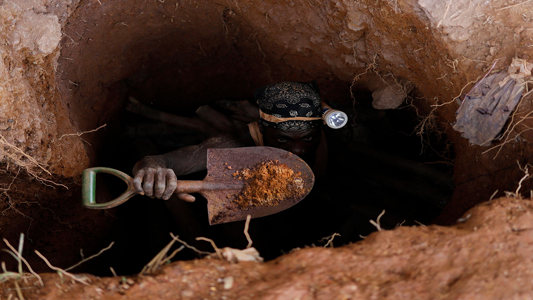 File Photo: An illegal miner holds a spade