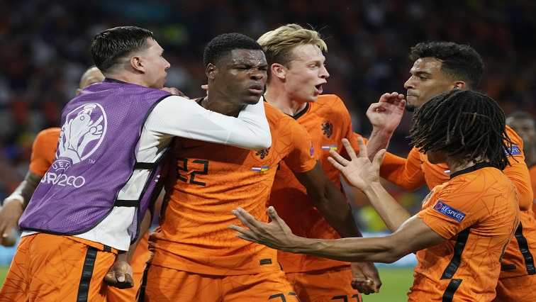 Netherlands' Denzel Dumfries celebrates scoring their third goal with teammates.
