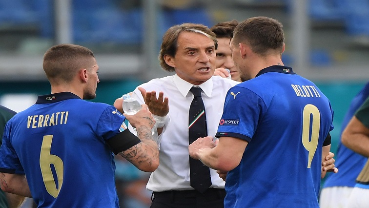 Italy coach Roberto Mancini talks to Andrea Belotti during the match.