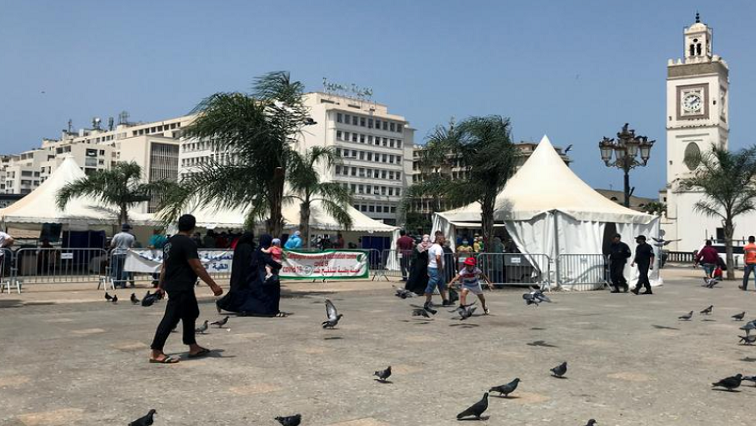 People walk past tents erected during a coronavirus disease (COVID-19) vaccination campaign that is taking place outside mosques, after Friday Prayers in Algiers, Algeria July 9, 2021.
