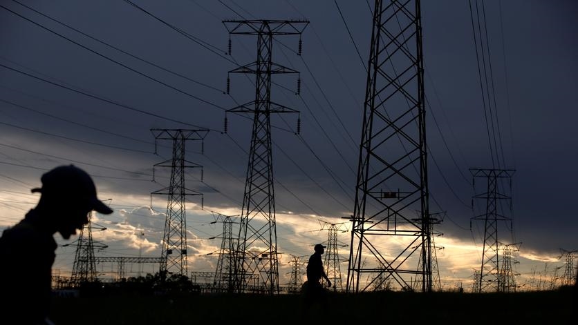 File image of a person walking past electricity   supply towers.