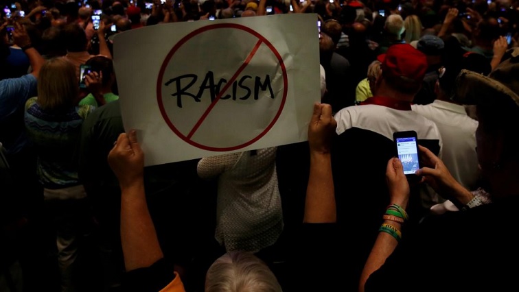 [File Image] A person holds an anti-racism placard.