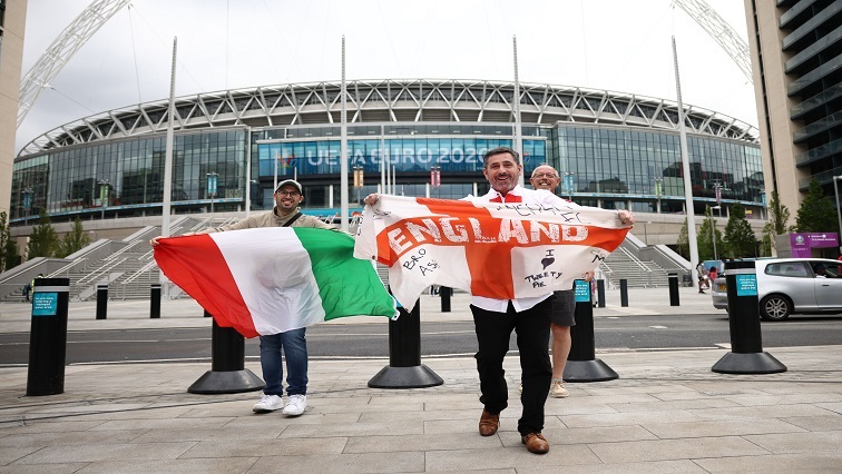 An England fan and an Italy fan pose with flags outside Wembley stadium ahead of the Euro 2020 final between England and Italy.