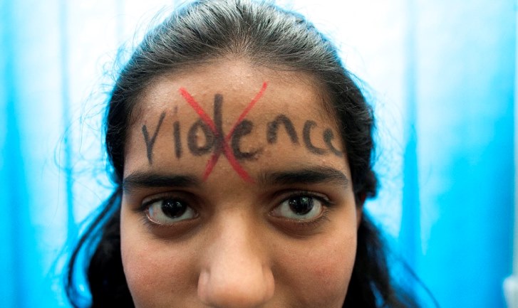 A woman has anti-violence slogan written on her forehead