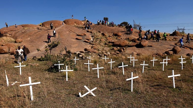 [File photo] Members of the mining community walk near crosses placed at a hill known as the "Hill of Horror", where 43 miners died during clashes with police , during a strike at Lonmin's Marikana platinum mine in Rustenburg.