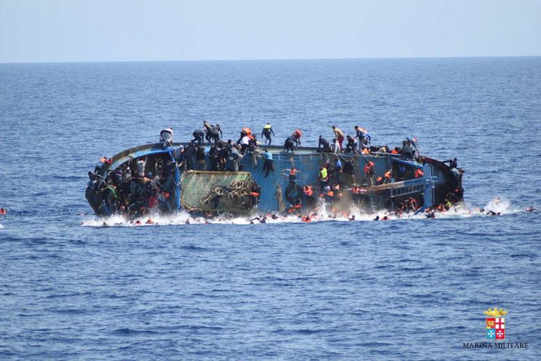 Migrants are seen on a capsizing boat before a rescue operation by Italian navy ships "Bettica" and "Bergamini" off the coast of Libya in this handout picture released by the Italian Marina Militare on May 25, 2016