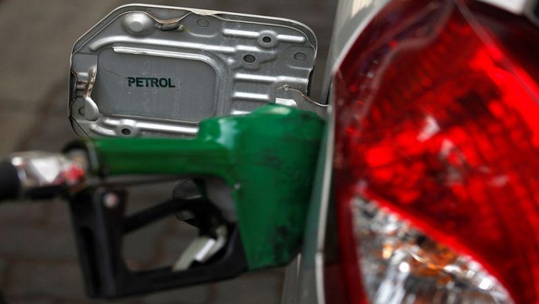 A nozzle pumps petrol into a vehicle at a fuel station.