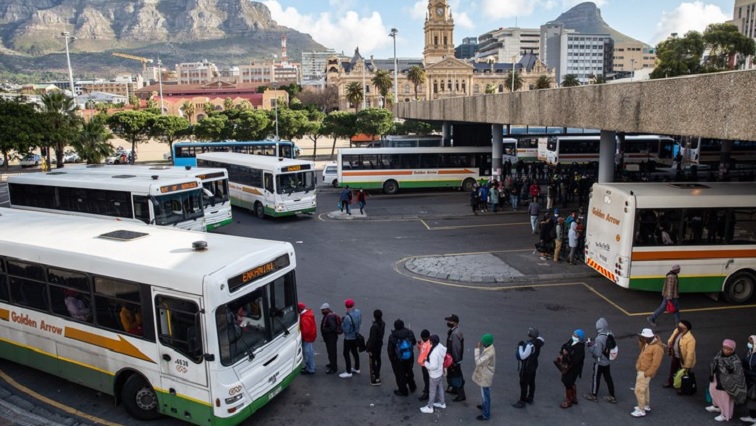Commuters wait for a bus at the Cape Town central station on 20 July 2021.