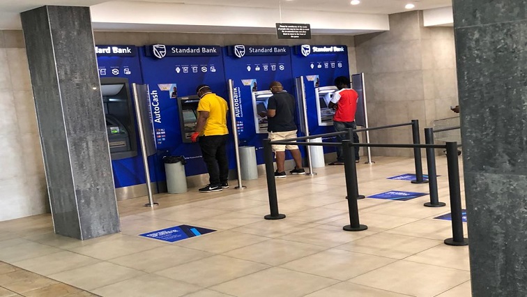 Customers can been seen standing next to automated teller machines (ATM).