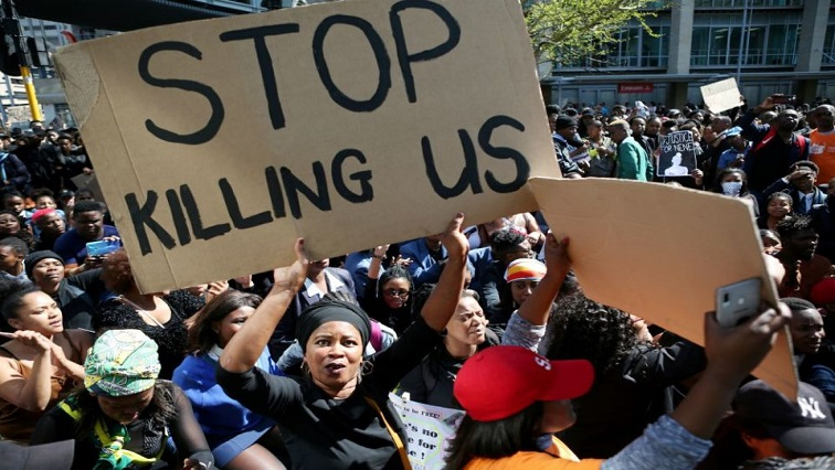 File Image: A woman holds a sign as demonstrators gather on September 4, 2019, at the World Economic Forum on Africa in Cape Town, South Africa, during a protest against gender-based violence.