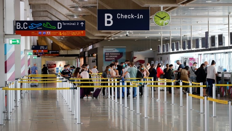 Travellers line up at a check-in counter of the Cologne-Bonn Airport, as the spread of COVID-19 continues, in Cologne, July 28, 2020.