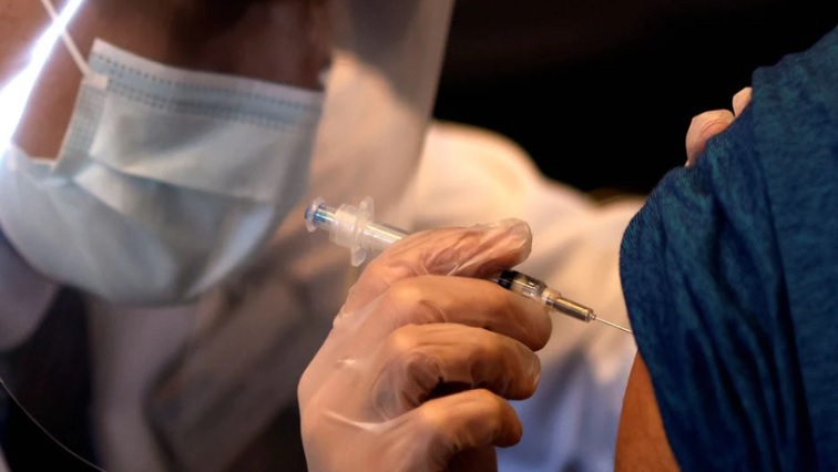 A healthcare workers administers a COVID-19 vaccine.