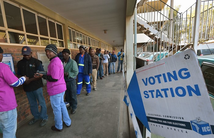People queue at a voting station to vote.