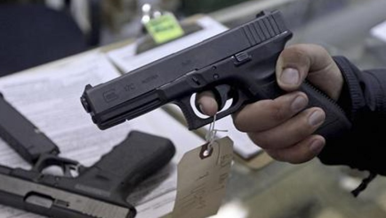 A customer looks over a Glock 17 9mm hand gun at the Guns-R-Us gun shop in Phoenix, Arizona, December 20, 2012.