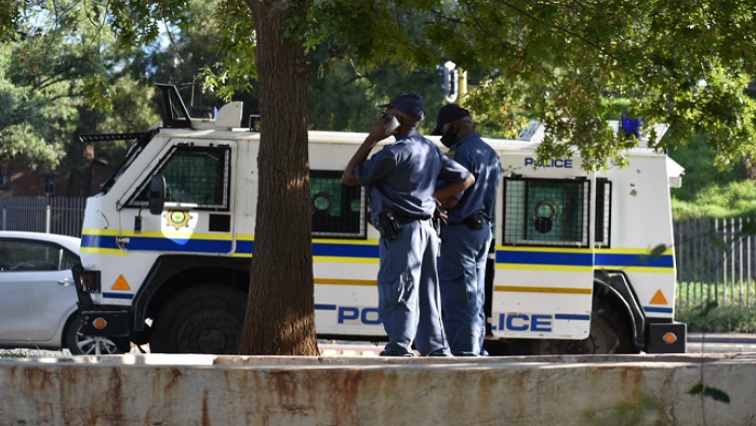 File Picture:  Police officers standing near a police van.