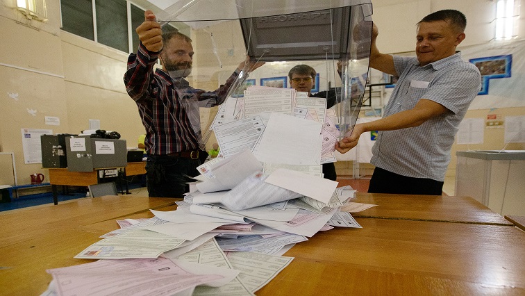 Members of a local election commission empty a ballot box.