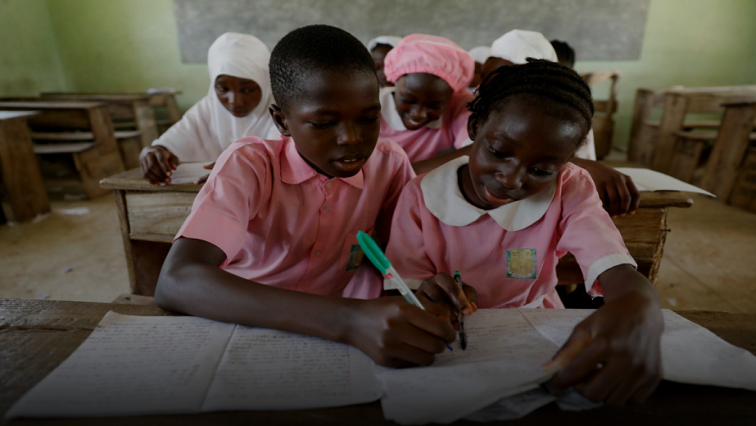 Quareebullahi Ajenifuja, 12, and Joy Adeniji, 12, take notes together during class at Ilorin Grammar school, in Ilorin, Kwara state, Nigeria.