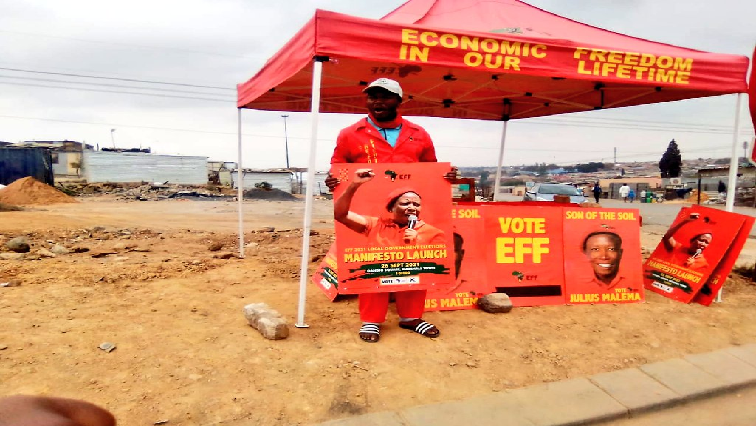 A member of the Economic Freedom Fighters holds a poster.