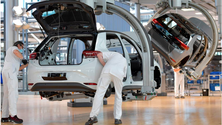 Technicians work in the assembly line of German carmaker Volkswagen's electric ID. 3 car in Dresden, Germany, June 8, 2021. REUTERS/Matthias Rietschel